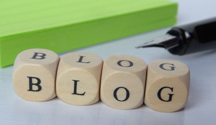 Letters-B-L-O-G-on-little-wooden-dice-beside-pad-of-green-paper