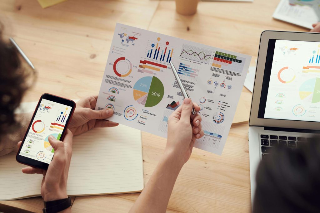 Hand-holding-paper-showing-charts-and-progress