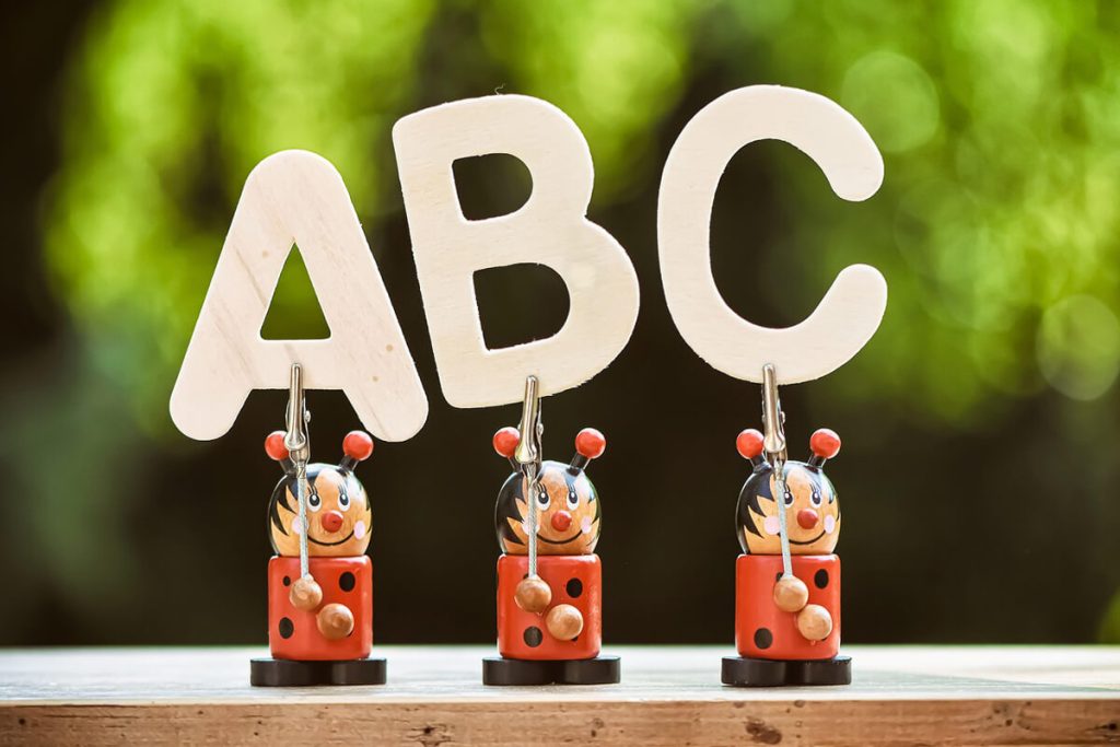 Three-toy-ladybirds-holding-up-the-letters-a-b-and-c