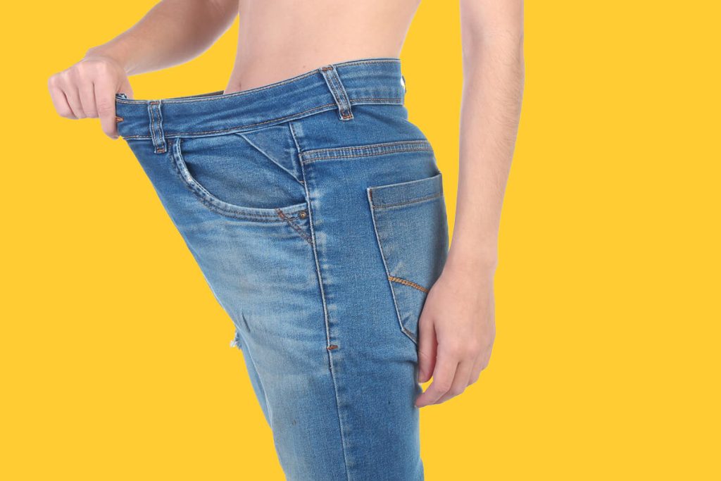 Woman-with-loose-jeans-on-yellow-background